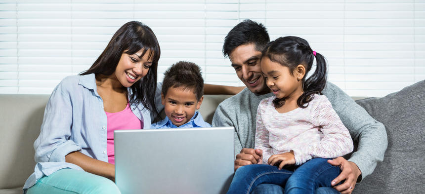 family looking at laptop