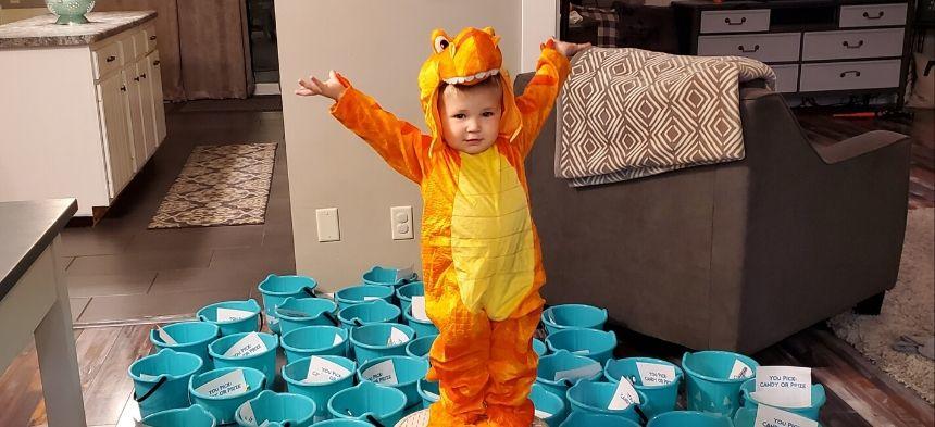Kid dressed as Dino with Teal Halloween Buckets