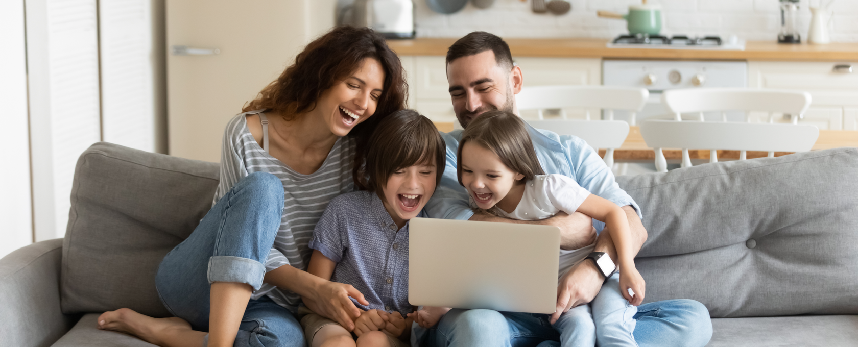 Family sitting on couch looking at a computer