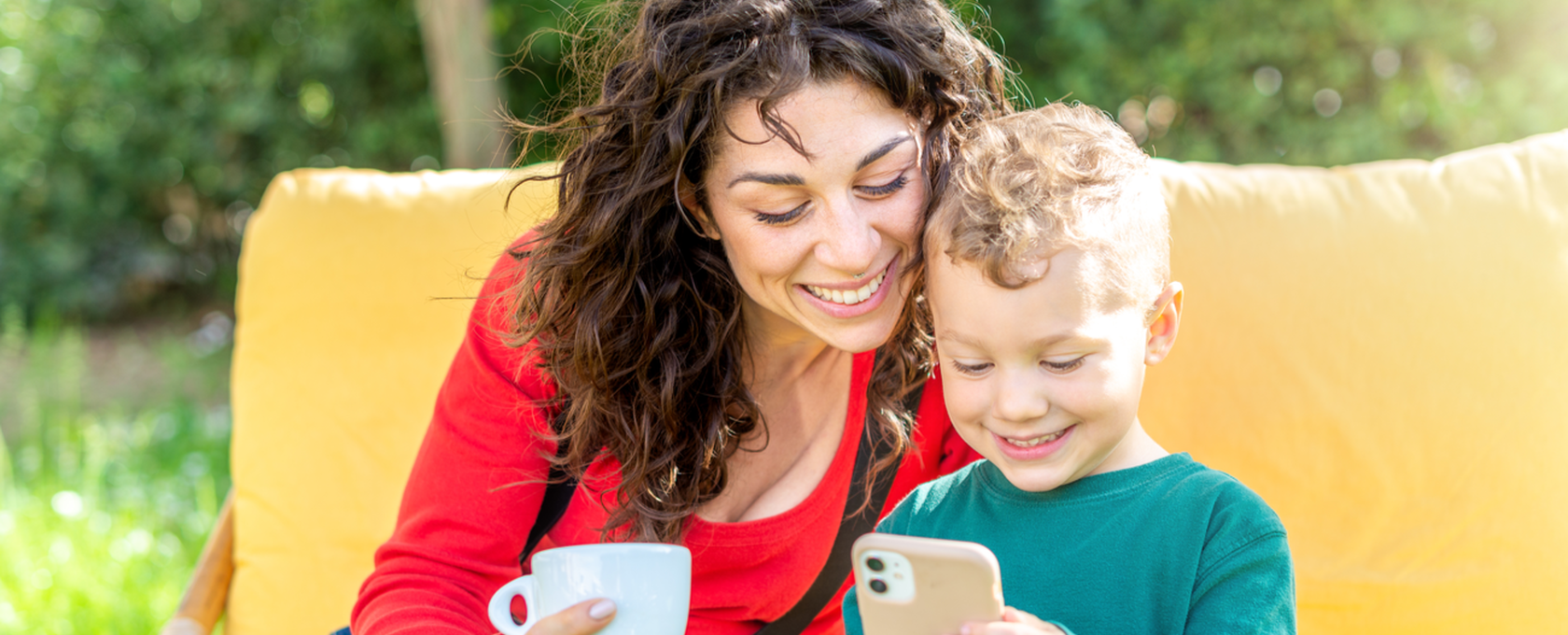 mom and kid watching videos on a phone outside