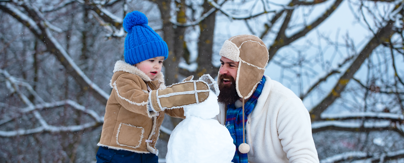 dad and son building a snowman