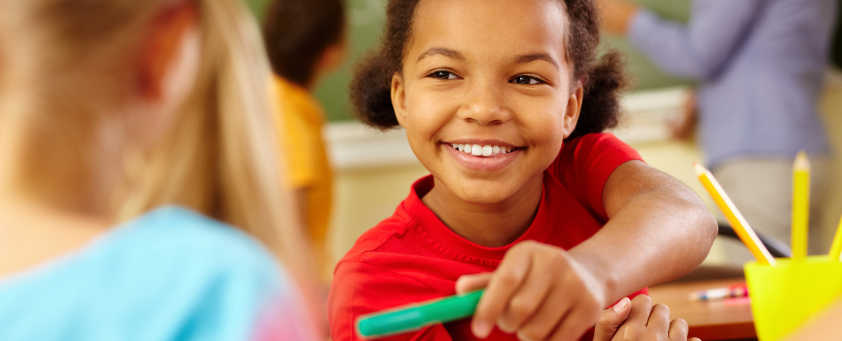 Girl sharing a marker with her friend