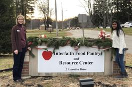 Standing next to food bank sign