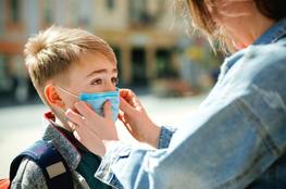 mom adjusting son mask