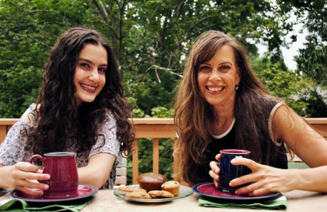 Mom (Rachel) and daughter (Leah) holding mugs, eating breakfast