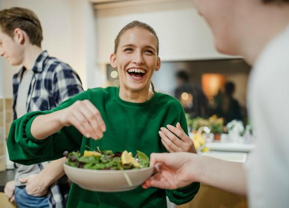 woman laughing making lunch at work