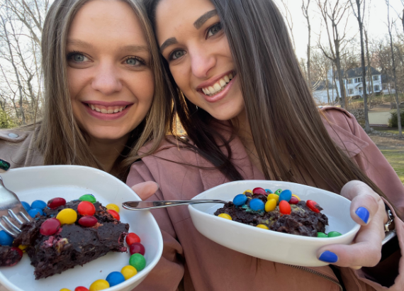 Sarah and Brooke holding up their secret brownies in bowls