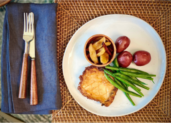 Plated schnitzel next to fork and knife