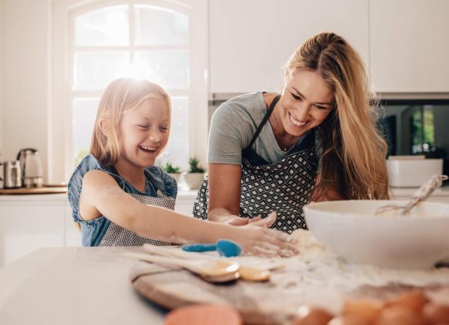 Mother and daughter baking in kitchen