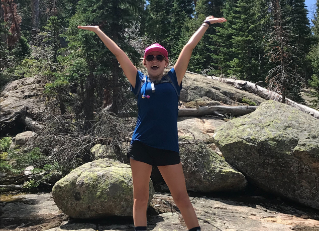 Teen hiking, arms up in excitement
