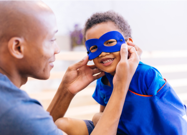 Dad helping super son put his mask on