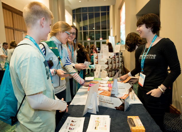 Summit vendor talking to attendees