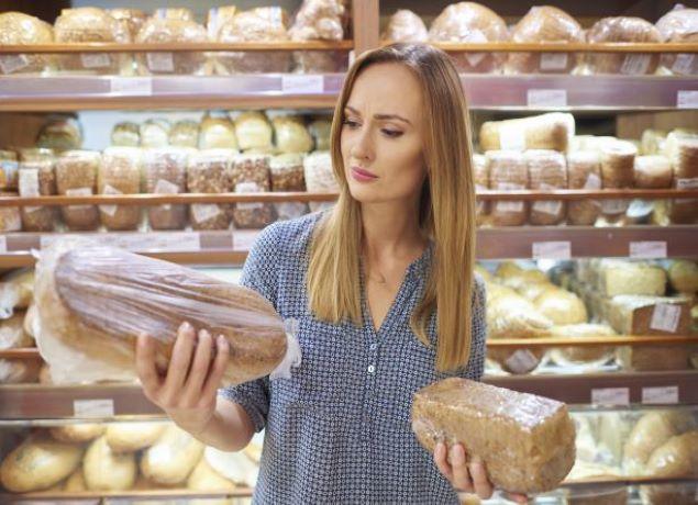 woman comparing two loaves of bread