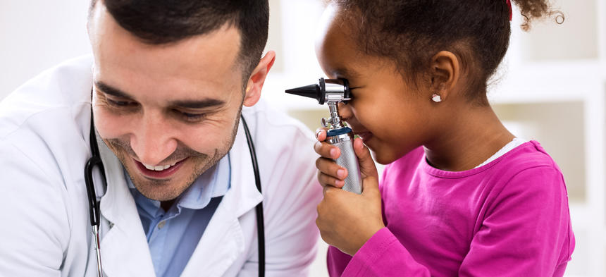 child looking in doctor's ear