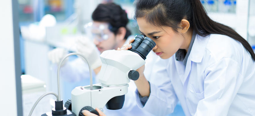 scientist looking in microscope