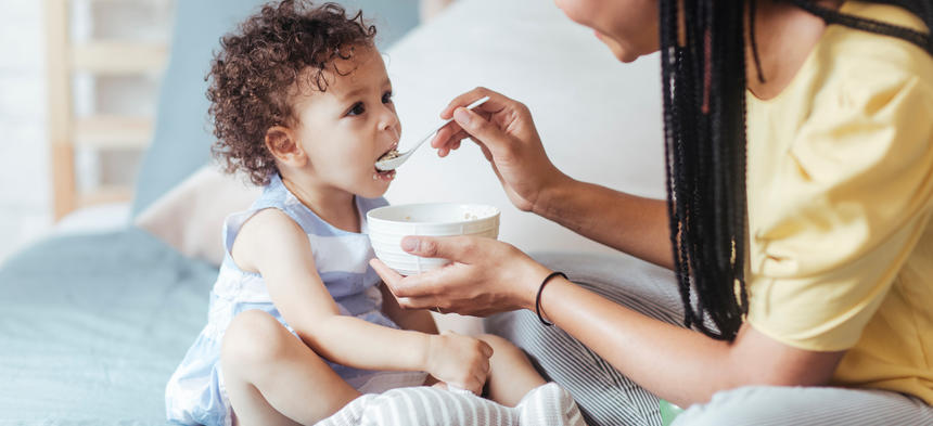 woman feeding child