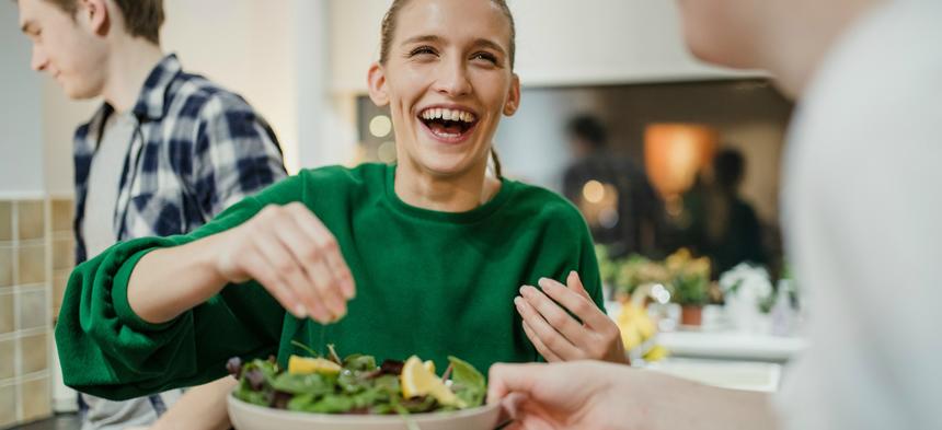 woman laughing making lunch at work