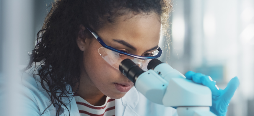 Researcher looking through microscope